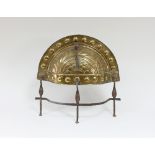 A brass and steel curfew guard, gadrooned brass on an iron stand,