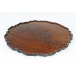 A circular mahogany tray with piecrust border, 53.