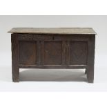 A 17th Century oak chest with plank lid and sides and a three-lozenge carved panelled front,