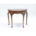 A walnut half-round table of Queen Anne design, fitted one drawer and raised on carved cabriole legs