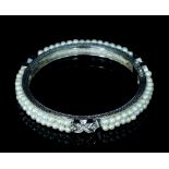 A diamond and pearl bangle, of hinged form,