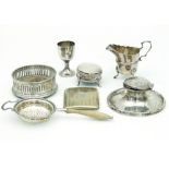 A silver capstan inkwell, Birmingham 1910, a cream jug, an egg cup, a bottle coaster, a strainer,
