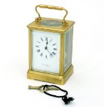 A carriage clock with alarm, in a gilt brass case, the white enamel dial with Roman numerals,