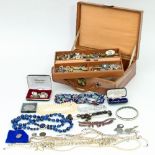 A large quantity of costume jewellery including strings of beads, earrings, enamel brooches,