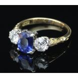 A sapphire and diamond three-stone ring, the central cushion shaped sapphire flanked by diamonds,