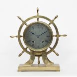 A brass ship's wheel mantel clock, the silvered dial with Roman numerals,