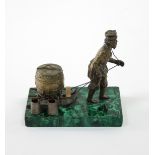 A Russian gilt metal ink stand modelled as a figure pulling a sledge,