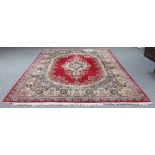 A Kerman carpet with all over floral field and central red ground medallion within a figured and