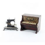 A child's toy piano and a child's sewing machine, the piano with keys playing an interior xylophone,