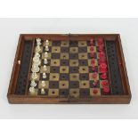 A Victorian Jaques & Son travelling chess set, with red and white ivory chess pieces,