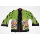 A lady's Chinese embroidered silk jacket, decorated flowers on a green ground,