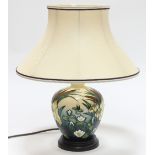 A Moorcroft 'Lamia' table lamp, tubeline decorated, mounted on a wooden circular base,