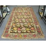 A large Kelim rug, multi-coloured rosettes on a brown ground,