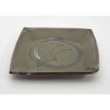 Russell Collins/A stoneware green glazed square pressed dish with iron oxide and red dot decoration,