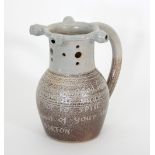 Russell Collins/A stoneware salt glazed puzzle jug with brown slip and incised decoration,