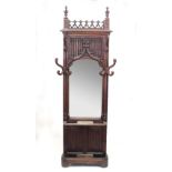 A Victorian gothic oak hall stand with poppy finials and pierced frieze with tracery arches to the