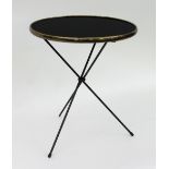 A French Art Deco style occasional table with circular black top within a brass rim on collapsible