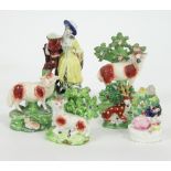 A group of six Staffordshire figures to include a small deer with tree behind,