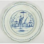 A creamware dish painted an Oriental figure in a garden within a landscape,