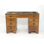 An oak kneehole desk fitted a surround of seven drawers on bracket feet,