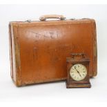 A tan leather suitcase, mounted with white metal locks,