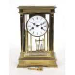 A brass four-glass mantel clock by The London Clock Company, fitted an eight-day movement,
