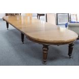 A Victorian oak extending dining table with half round ends and moulded border,