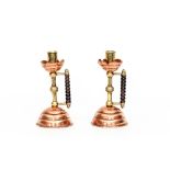 A pair of copper, brass and wooden candlesticks to a design by Dr Christopher Dresser,