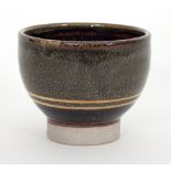 Russell Collins/A stoneware tea bowl with white over black glaze and a 24ct gold band,