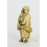 A carved okimono, Meiji period, depicting a standing man wearing flowing robes,