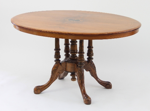 A Victorian walnut oval loo table, with inlaid central foliate oval on a quadruple column support,