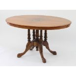 A Victorian walnut oval loo table, with inlaid central foliate oval on a quadruple column support,