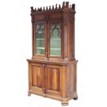 A Victorian gothic walnut bookcase with castellated corners to the cornice and with trefoil finials