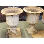 A pair of Coalbrookdale urns, with fluted sides on square bases,