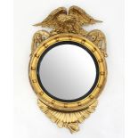 A Regency giltwood convex wall mirror, with eagle surmount and ball studded frame,
