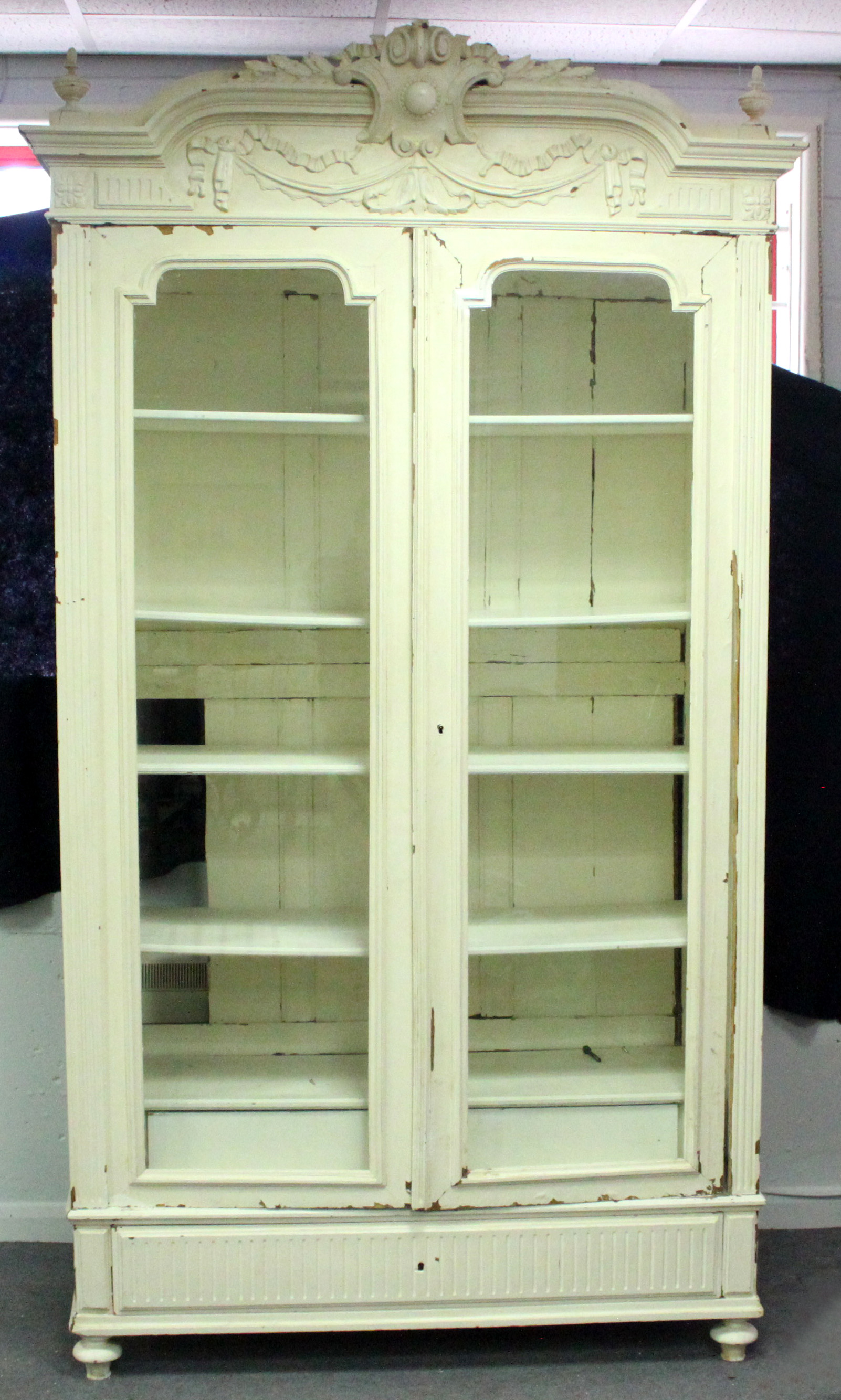 A painted French armoire, enclosed by glazed panel doors above a drawer,