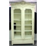 A painted French armoire, enclosed by glazed panel doors above a drawer,