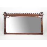 A Victorian gothic oak overmantel with carved end finials and frieze of seventeen finials,