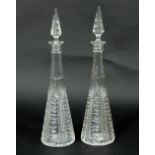 A pair of cut glass decanters of tall form with circular bases,