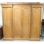 A Victorian oak breakfront wardrobe, fitted for hanging with moulded cornice,