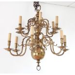 A Dutch brass twelve-light chandelier with two tiers each of six lights with scroll branches,