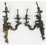 A pair of two-branch gilt metal wall lights, of scrolling foliate form,