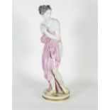 An Italian glazed figure of a semi-clad maiden on a circular base,