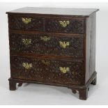 An 18th Century oak chest of two long and two short drawers with later carved fronts on bracket