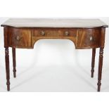 A Regency walnut dressing table fitted with three drawers within a shaped apron on turned and