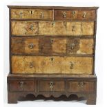 An early 18th Century walnut chest of two short over three long drawers, on a three drawer stand,