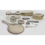 A matched silver mounted dressing table set, comprising hand mirror, two hair brushes (one damaged),