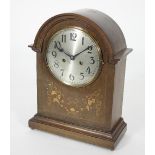 An early 19th Century arch top mantel clock in an inlaid case fitted an eight-day movement striking
