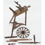 A cherry wood spinning wheel, the bobbin turned wheel with brass rim,