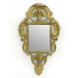 An early 19th Century giltwood wall mirror with shaped surround carved with scrolling acanthus